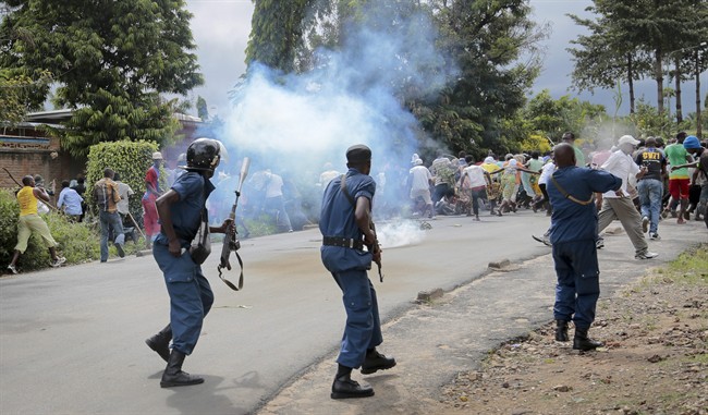 Demonstrators trying to march to the town center flee as police disperse them with tear gas, in the Ngagara district of Bujumbura, Burundi Wednesday, May 13, 2015