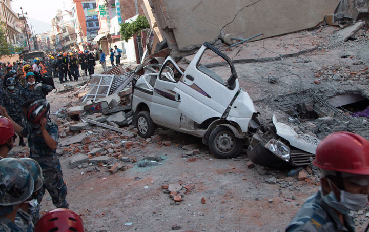 A car is seen smashed under the weight of a building that collapsed in an earthquake in Kathmandu, Nepal, Tuesday, May 12, 2015.