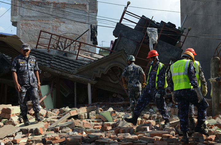 Rescue team officials inspect the site of a collapsed house in Kathmandu May 12, 2015.