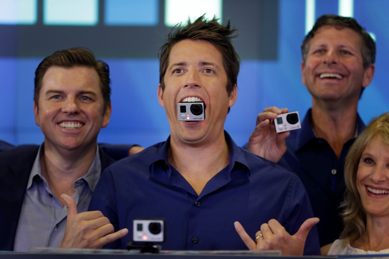 GoPro's CEO Nick Woodman holds a GoPro camera in his mouth as he celebrates his company's IPO at the Nasdaq MarketSite in New York, Thursday, June 26, 2014.