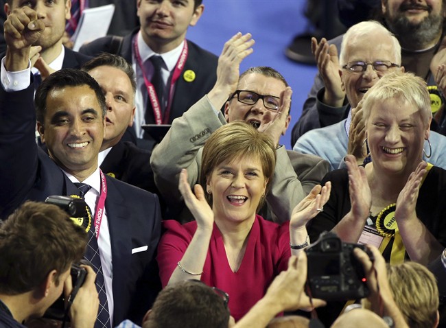 First Minister of Scotland and Scottish National Party leader Nicola Sturgeon, center, celebrates with the results for her party at the count of Glasgow constituencies for the general election in Glasgow, Scotland, Friday, May 8, 2015. The Conservative Party fared much better than expected in Britain's parliamentary election, with an exit poll and early returns suggesting that Prime Minister David Cameron would remain in his office at 10 Downing Street.