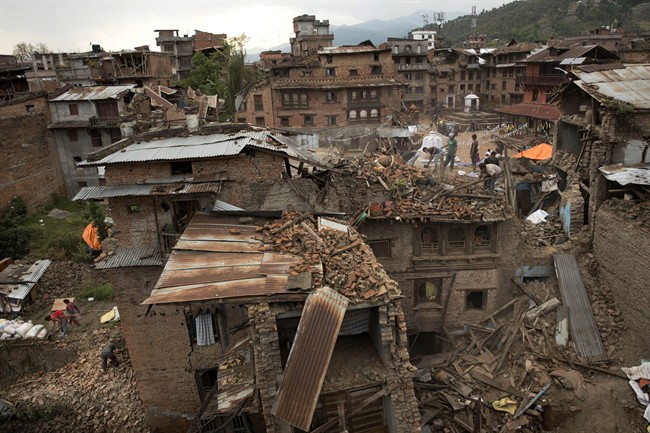 FILE - In this April 29, 2015 file photo, people clear the debris from damage caused by an earthquake in Sakhu, on the outskirts of Kathmandu, Nepal. 