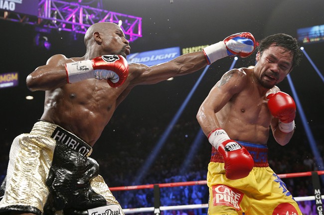 In this May 2, 2015 file photo, Floyd Mayweather Jr., left, hits Manny Pacquiao, from the Philippines, during their welterweight title fight in Las Vegas. 