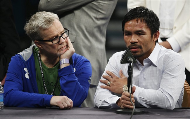 FILE - In this May 2, 2015 photo, trainer Freddie Roach, left, listens as Manny Pacquiao answers questions during a press conference following his welterweight title fight against Floyd Mayweather Jr. in Las Vegas.