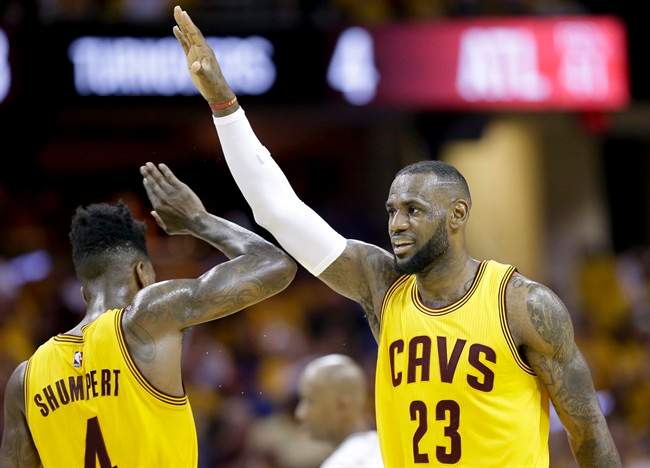 Cleveland Cavaliers forward LeBron James (23) high fives guard Iman Shumpert (4) during a timeout in the first half of Game 4 of the NBA basketball Eastern Conference Finals against the Atlanta Hawks Tuesday, May 26, 2015, in Cleveland. 