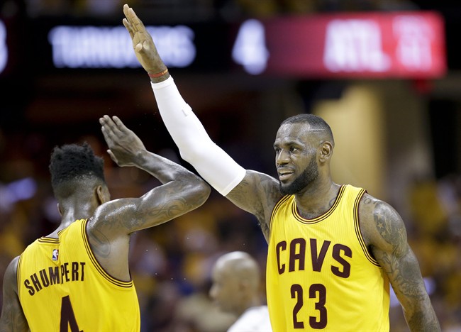 Cleveland Cavaliers forward LeBron James (23) high fives guard Iman Shumpert (4) during a timeout in the first half of Game 4 of the NBA basketball Eastern Conference Finals against the Atlanta Hawks Tuesday, May 26, 2015, in Cleveland. 