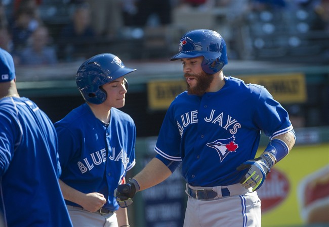 Toronto Blue Jays' Russell Martin, right, heads to the dugout past an unidentified bat boy after hitting a home run off Cleveland Indians pitcher Corey Kluber during the fourth inning of a baseball game in Cleveland, Saturday, May 2, 2015.