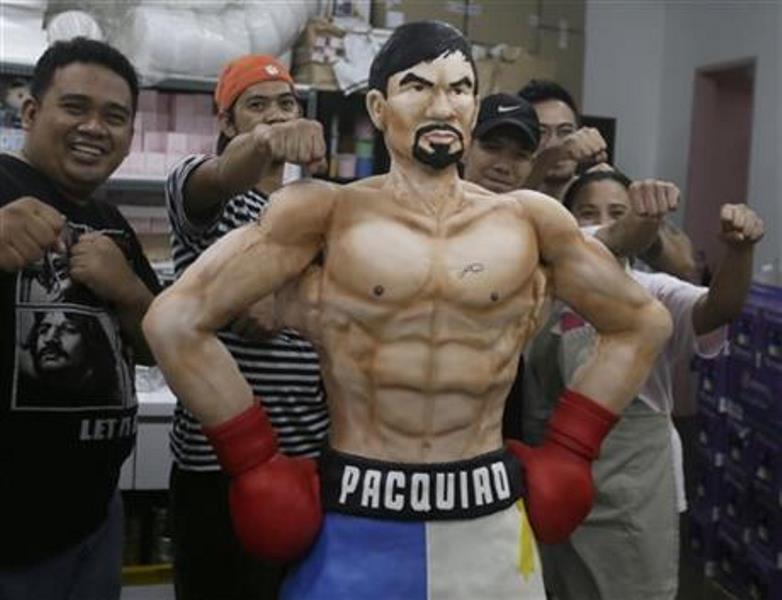 ach Yonzon, second from right, owner of The Bunny Baker cafe, along with his staff poses with the life-sized cake of Filipino boxer Manny Pacquiao Saturday, May 2, 2015 at his bakeshop at suburban Quezon city, northeast of Manila, Philippines. Yonzon who says he was bored with making traditional cakes sculpted the one-of-a-kind life-sized cake in the image of Pacquiao to mark the Filipino champion’s megabout with American Floyd Mayweather. Yonzon, says his wife Aila and six of his staff helped finish the 167-centimeter (66-inch) chocolate cake of Pacquiao with arms akimbo on Saturday after working 24 hours at the cafe. 