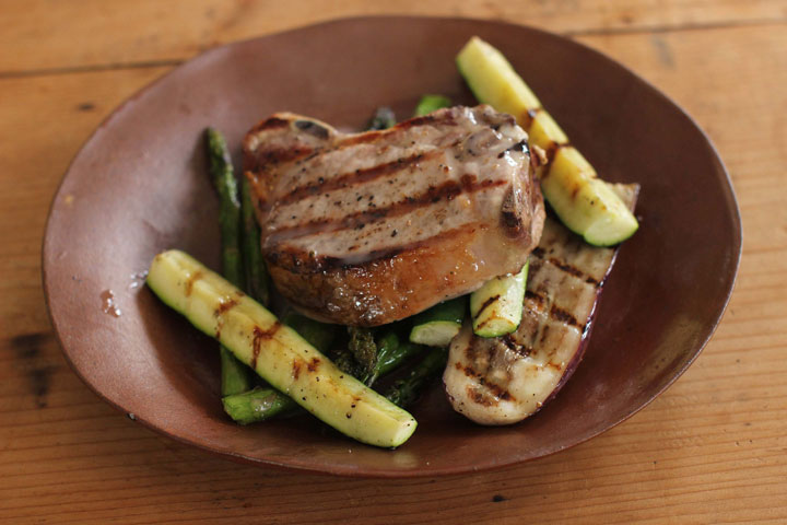 This April 6, 2015 photo shows grilled pork chops and asparagus with lemon truffle viaigrette in Concord, N.H.