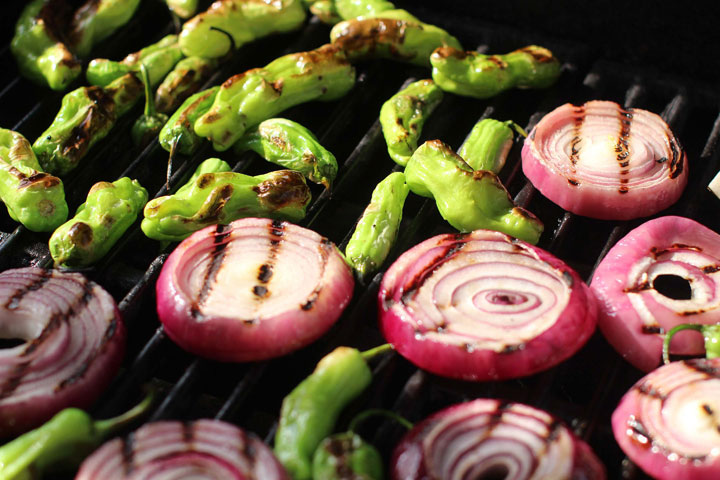 This April 6, 2015 photo shows grilled red onions and shishito peppers in Concord, N.H.