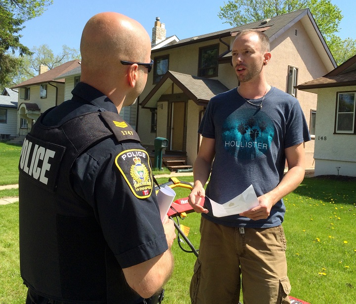 A Winnipeg police officer speaks to a River Heights resident about crime.