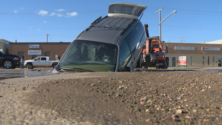 A woman thought she was driving over a pothole on a Saskatoon street. Instead, her minivan ended up in a sinkhole.