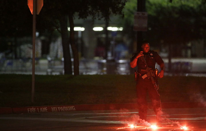 An police officer stands guard at a parking lot near the Curtis Culwell Center where a provocative contest for cartoon depictions of the Prophet Muhammad was held Sunday, May 3, 2015, in Garland, Texas.