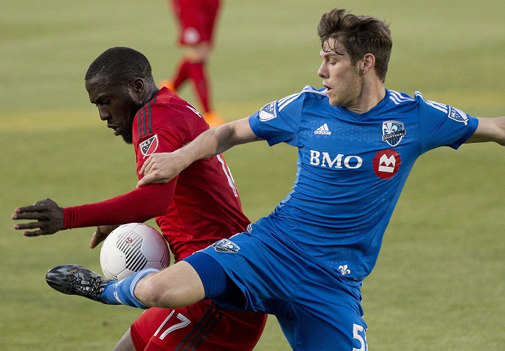 Toronto FC Jozy Altidore, left, battles for the ball against Montreal Impact Maxim Tissot, right, during first half semi-final Canadian Championship soccer action in Toronto on Wednesday, May 13, 2015. THE CANADIAN PRESS/Nathan Denette.
