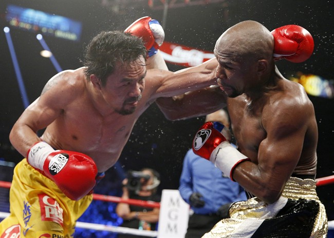 FILE - In this May 2, 2015 file photo, Manny Pacquiao, left, from the Philippines, trades blows with Floyd Mayweather Jr., during their welterweight title fight in Las Vegas. Pacquiao lost his biggest fight in the ring, but that won’t stop him from plotting a bigger comeback - in the political arena that is. Some fans still want a rematch because they felt cheated by the lackluster Pacquiao-Mayweather bout billed by promoters as the “Battle for Greatness,” though boxing analyst Ed Tolentino calls it the “Fiasco of the Century.” (AP Photo/John Locher, File).
