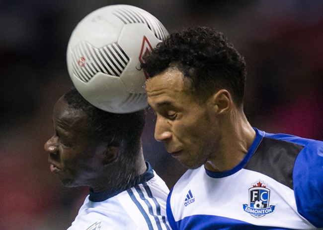 Vancouver Whitecaps' Kekuta Manneh, left, of Gambia, and FC Edmonton's Cristian Raudales vie for the ball during the second half of a Canadian Championship semifinal soccer game in Vancouver, B.C., on Wednesday May 13, 2015. 
