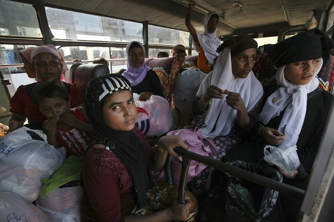 Ethnic Rohingya women sit inside a bus as they are transferred from a sports stadium to another temporary shelter for the migrants whose boats were washed ashore on Sumatra island on Sunday, in Lhoksukon, Aceh province, Indonesia, Wednesday, May 13, 2015. More than 1,600 migrants and refugees have landed on the shores of Malaysia and Indonesia in the past week and thousands more are believed to have been abandoned at sea, floating on boats with little or no food after traffickers literally jumped ship fearing a crackdown. (AP Photo/Binsar Bakkara).