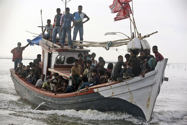 An Acehnese fishing boat full of rescued migrants approaches to dock in Simpang Tiga, Aceh province, Indonesia, Wednesday, May 20, 2015.