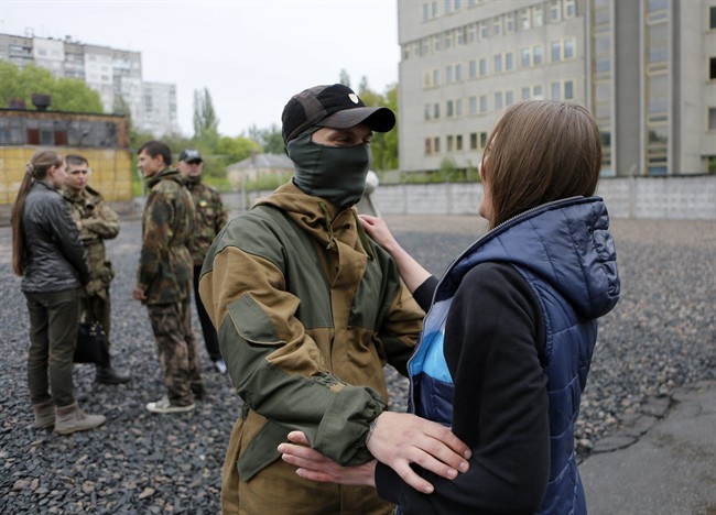 Friends and relatives say goodbye to volunteers being sent to the eastern part of Ukraine to join the ranks of special battalion "Azov" fighting against pro-Russian separatists, in Kiev, Ukraine, Thursday, May 7, 2015.