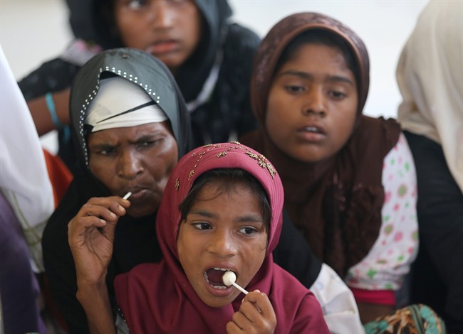 Ethnic rohingya women eat candy at a temporary shelter in Lhoksukon, Aceh province, Indonesia, Thursday, May 21, 2015.
