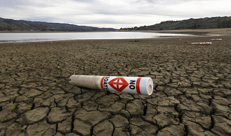 A warning buoy sits on the dry, cracked bed of Lake Mendocino near Ukiah, Calif.