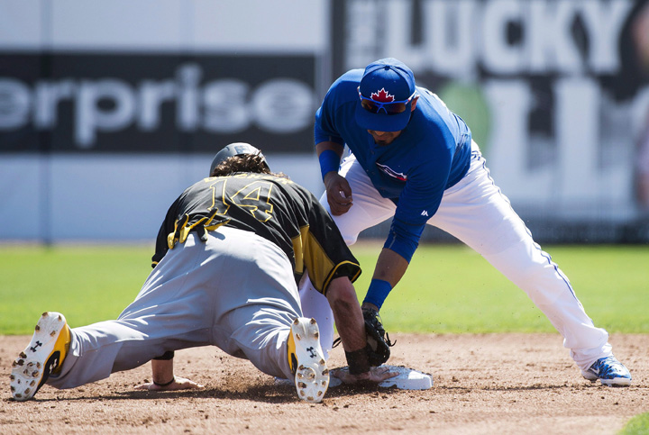 Pittsburgh Pirates centre fielder Jaff Decker (14) slides safely back to second base after leading off as Toronto Blue Jays second baseman Maicer Izturis, right, is late on the tag during second inning Grapefruit League baseball action in Dunedin, Fla., on Tuesday, March 3, 2015. 