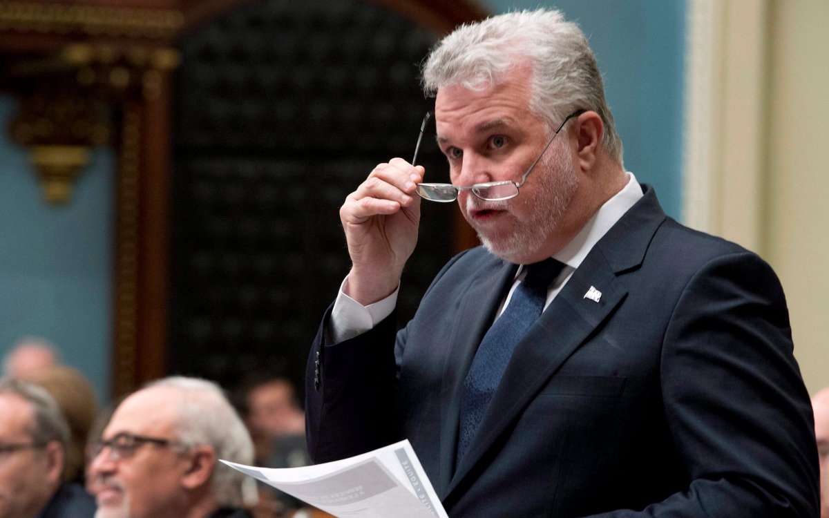 Quebec Premier Philippe Couillard responds to the Opposition during question period Monday, April 20, 2015 at the legislature in Quebec City. Quebec Finance Minister Carlos Leitao, left, looks on.