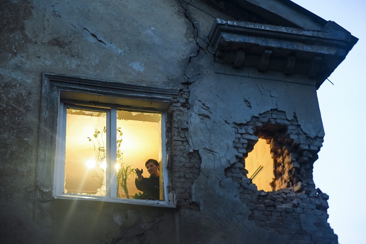 People observe damage in their flat after shelling between Russia-backed separatists and Ukrainian government troops in Donetsk, Eastern Ukraine Monday, June 1, 2015. In a new report released Monday, the U.N. human rights office said that the number of people killed in more than a year of fighting in the east has risen to more than 6,400 people. (AP Photo/Mstyslav Chernov).
