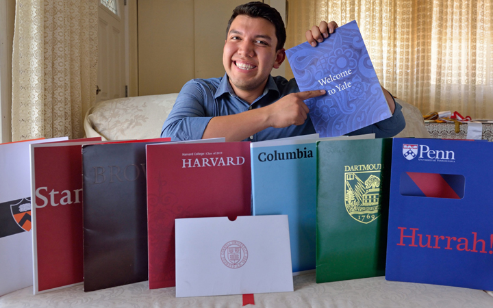 Fernando Rojas, 17, a Fullerton High School graduate, poses for a photo in Fullerton, Calif. with literature from the eight Ivy League universities he was accepted into. He decided to attend Yale.