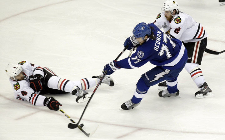 Tampa Bay Lightning defenseman Victor Hedman shoots under pressures from Chicago Blackhawks defenseman during the third period in Game 2 of the NHL hockey Stanley Cup Final on Saturday, June 6, 2015, in Tampa Fla.