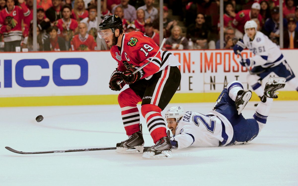 Tampa Bay Lightning's Ryan Callahan, right, falls as he chases after a loose puck along side Chicago Blackhawks' Jonathan Toews (19) during the third period in Game 4 of the NHL hockey Stanley Cup Final Wednesday, June 10, 2015, in Chicago. 