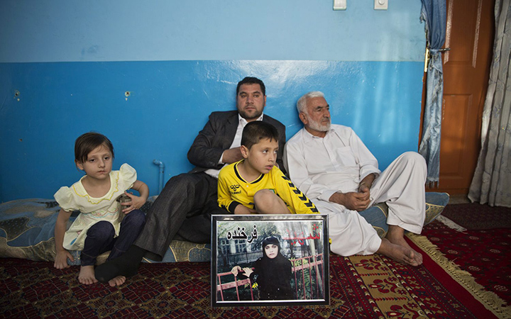 Mohammad Nader Malikzada, right, father of Farkhunda Malikzada, a young Afghan woman who was beaten to death by a mob, and his son, Najibullah Malikzada with Mohammad's grandchildren at his house in Kabul, Afghanistan on Sunday, June 14, 2015.