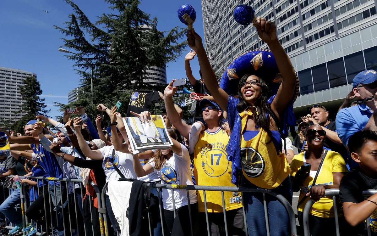 Fans cheer as the Golden State Warriors ride along during a parade and rally for winning the NBA championship in Oakland, Calif., Friday, June 19, 2015.