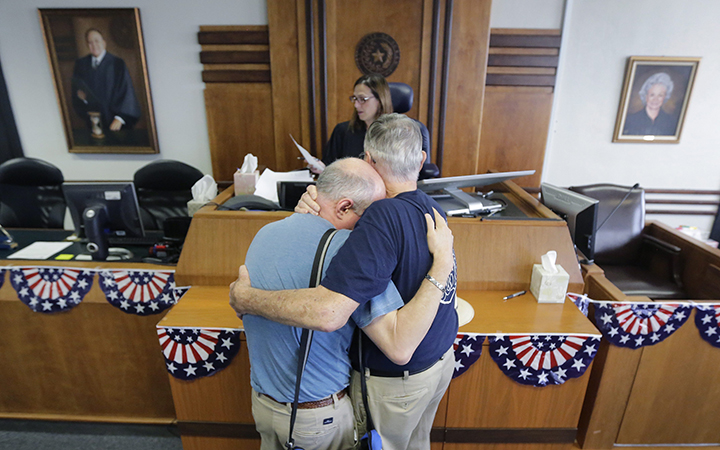 Gerald Gafford, right, comforts his partner of 28 years, Jeff Sralla, left, as they stand before Judge Amy Clark Meachum to receive obtain a time waiver at the Travis County Courthouse in Austin, Texas.