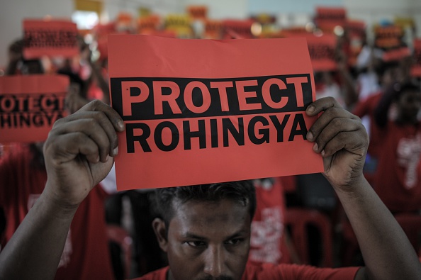 Ethnic Rohingya refugees from Myanmar residing in Malaysia hold placards during a rally over the current Rohingya crisis at a hall in Ampang, in the suburbs of Kuala Lumpur on June 3, 2015. A boat with more than 700 migrants being escorted by Myanmar's navy towards its western state of Rakhine is expected to reach land on June 3, according to a senior US official who demanded they be treated "humanely".