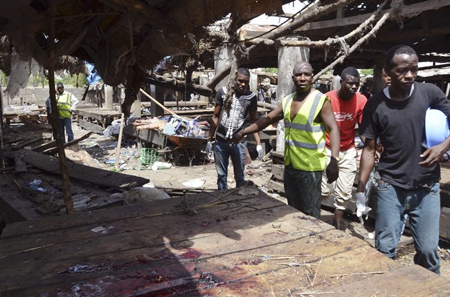 FILE - In this file photo taken on Tuesday, June 2, 2015, rescue workers at the site of a suicide bomb attack at a market in Maiduguri, Nigeria. 