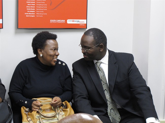 In this Tuesday, Nov. 26, 2012, file photo, state Sen. Clementa Pinckney, right, talks to a supporter during a break in a hearing protesting his re-election in Columbia, S.C.