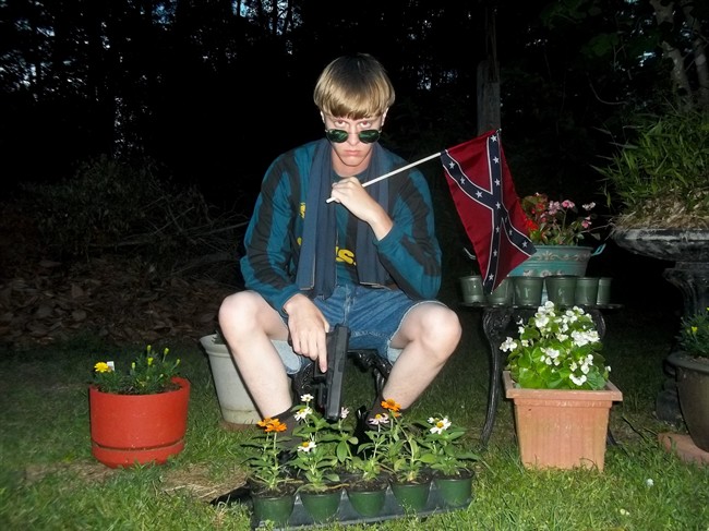 This undated file image that appeared on Lastrhodesian.com, a website being investigated by the FBI in connection with Charleston, S.C., shooting suspect Dylann Roof, shows Roof posing for a photo while holding a Confederate flag.