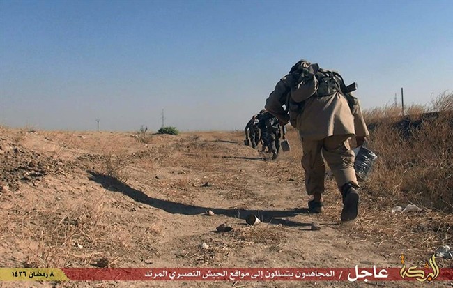 This photo provided by a website of the Islamic State militants, taken Thursday, June 25, 2015, shows fighters of the Islamic State group moving toward Syrian government forces' positions in the predominantly Kurdish Syrian city of Hassakeh, Syria.