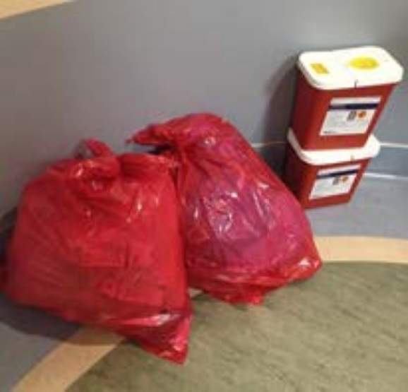 Biomedical waste left unattended in a hallway.