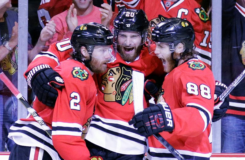 Chicago Blackhawks' Duncan Keith, left, is congratulated by teammates Brandon Saad and Patrick Kane, right, after scoring during the second period in Game 6 of the NHL hockey Stanley Cup Final series on against the Tampa Bay Lightning Monday, June 15, 2015, in Chicago. 