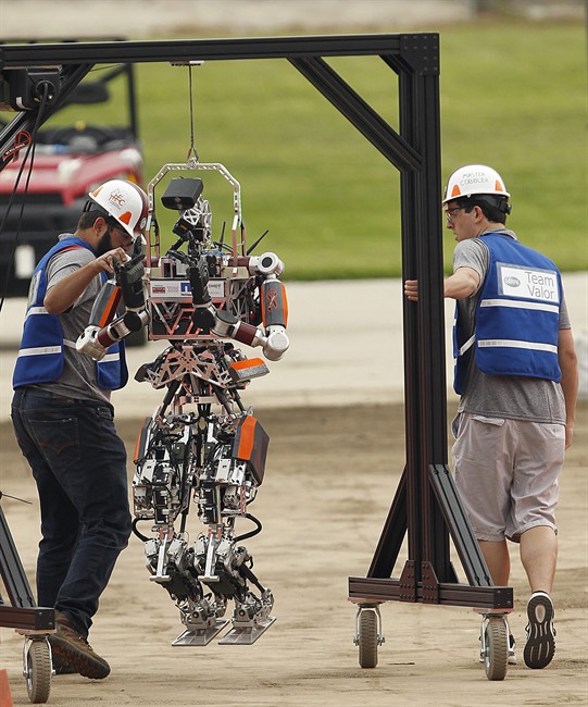 Robot Running Man from the Florida Institute for Human and Machine Cognition proceeds grabs a drill during the next stage of the competition in the U.S. Defense Advanced Research Projects Agency Robotics Challenge in Pomona, Calif., Friday, June 5, 2015.