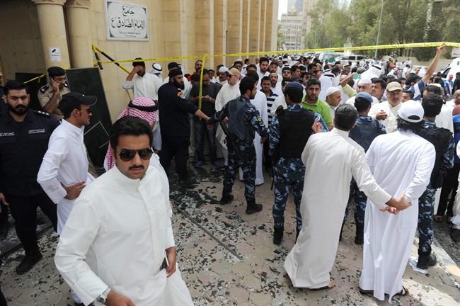 Security forces, officials and civilians gather after a deadly blast claimed by the Islamic State group that struck worshippers attending Friday prayers at a Shiite mosque in Kuwait City, Friday, June 26, 2015. 