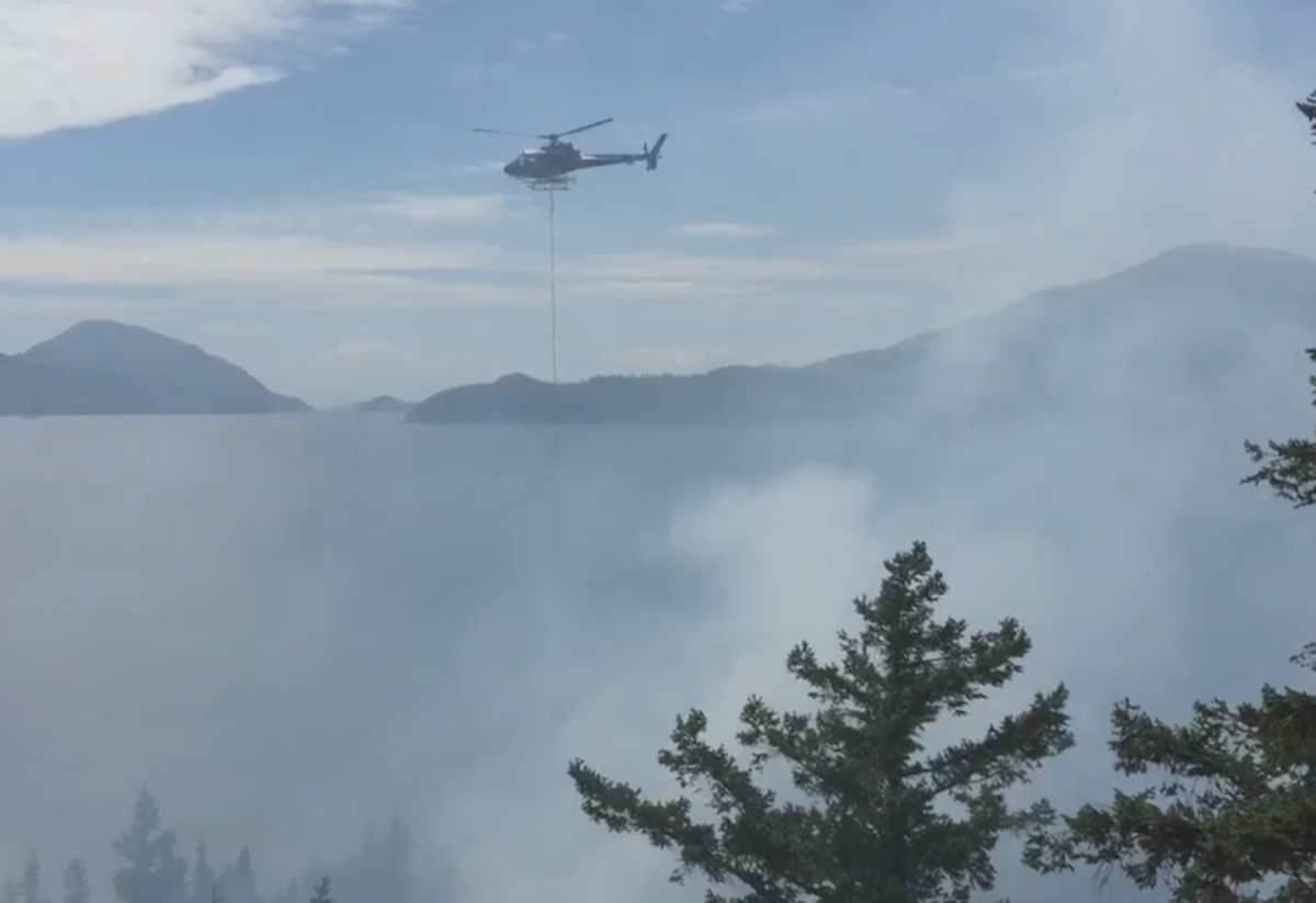 Crews in Lions Bay respond to a fire between the rail line and Howe Sound on June 17, 2015.