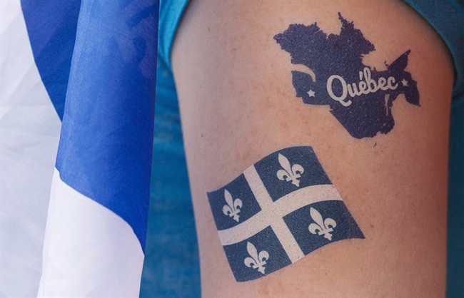 A woman wears a map of Quebec and a Fleur de Lys on her arm.