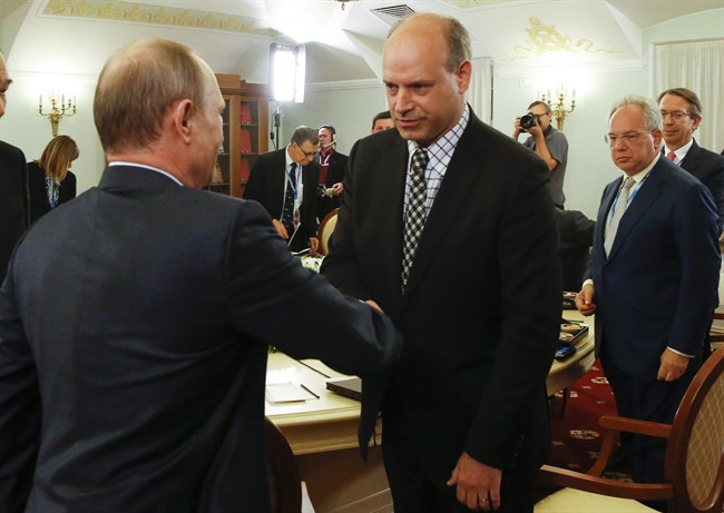 Russian President Vladimir Putin shakes hands with Canadian Press President Malcolm Kirk, right, at the St. Petersburg International Investment Forum in St.Petersburg, Russia, Friday, June 19, 2015. 