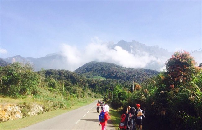Tourists walk away from Mount Kinabalu hours after a magnitude 5.9 earthquake shook the area in Kundasang, Sabah, Malaysia, Friday, June 5, 2015. Malaysian officials said a group of foreigners - including two Canadians - took nude photos on the country's highest mountain peak which is considered to be sacred.
