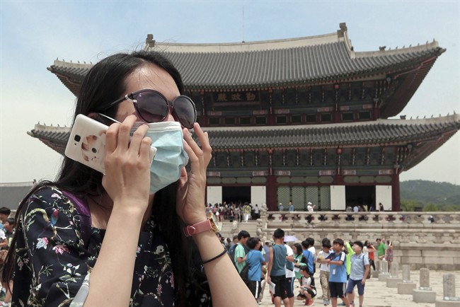 An unidentified Chinese tourist wearing a mask by way of precaution against the Middle East Respiratory Syndrome virus visits Gyeongbok Palace in Seoul, South Korea Monday, June 1, 2015. Authorities say more than 680 people in South Korea are placed in isolation after having contacts with those infected with a virus that has killed hundreds of people in the Middle East.