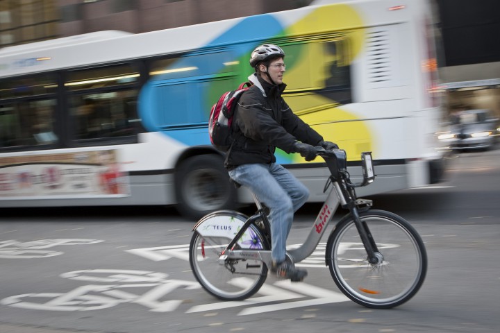 A man rides by an STM bus in downtown Montreal.