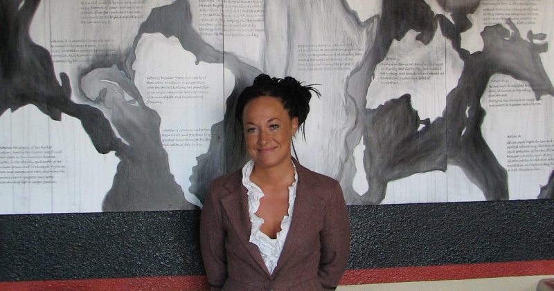 Rachel Dolezal, a leader of the Human Rights Education Institute, stands in front of a mural she painted at the institute's offices in Coeur d'Alene, Idaho. 